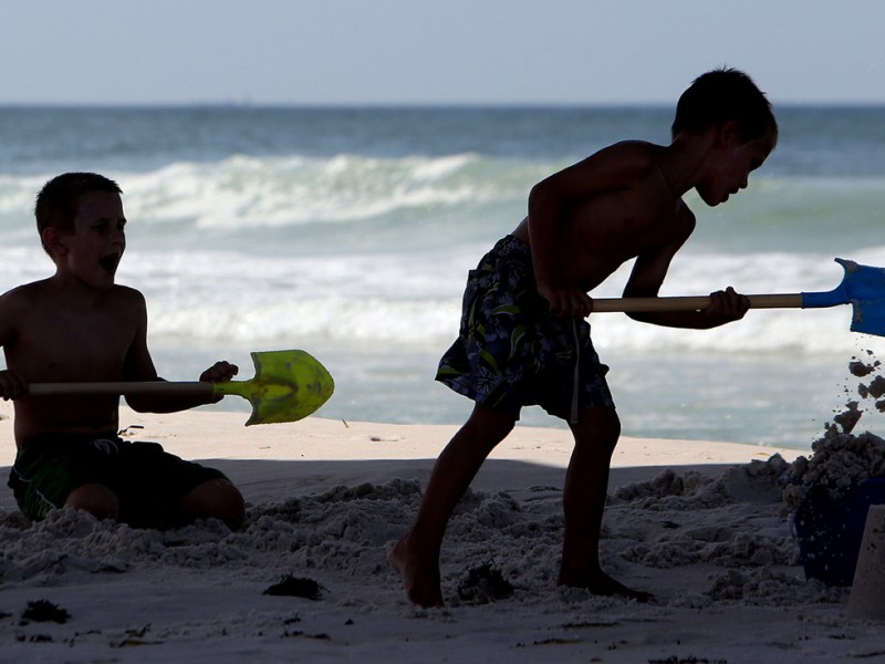 In this Monday, June 15, 2015, file photo, kids build a sand castle beneath the M.B. Miller County Pier in Panama City Beach, Fla.