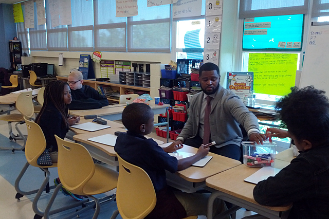 Fourth grade teacher Milton Bryant works with students in a small group during a blended learning session at Ketcham Elementary School. Elsewhere in the classroom students worked with other educators and on computers, and they rotated at intervals to each station. (Photo: Nichole Dobo)