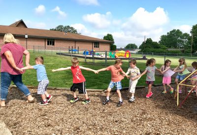 Pre-K students play a game with teaching assistant Johnni Hoene during recess at Zion Lutheran School in Seymour, Indiana.