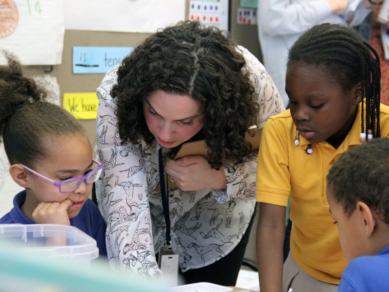 Sasha Redlener, a fourth-grade teacher at Mott Haven Academy Charter School, helps her students with an assignment. Classes at the school mix “body breaks” and other playtime with reading and math instruction and lessons in social and emotional skills.