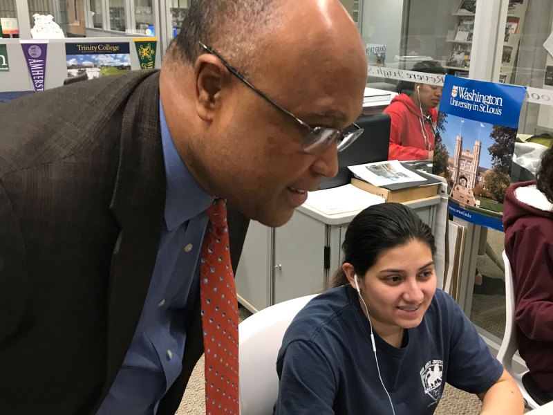 Lourenco Garcia, who earned national attention for his performance as principal at Revere High School, checks in with junior Fatima Vasquez as she works in the school’s writing center.